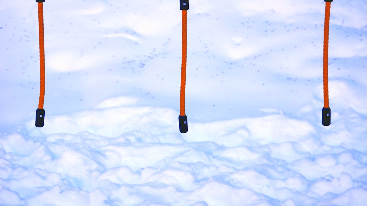 Orange cables hang above a snowy ground.