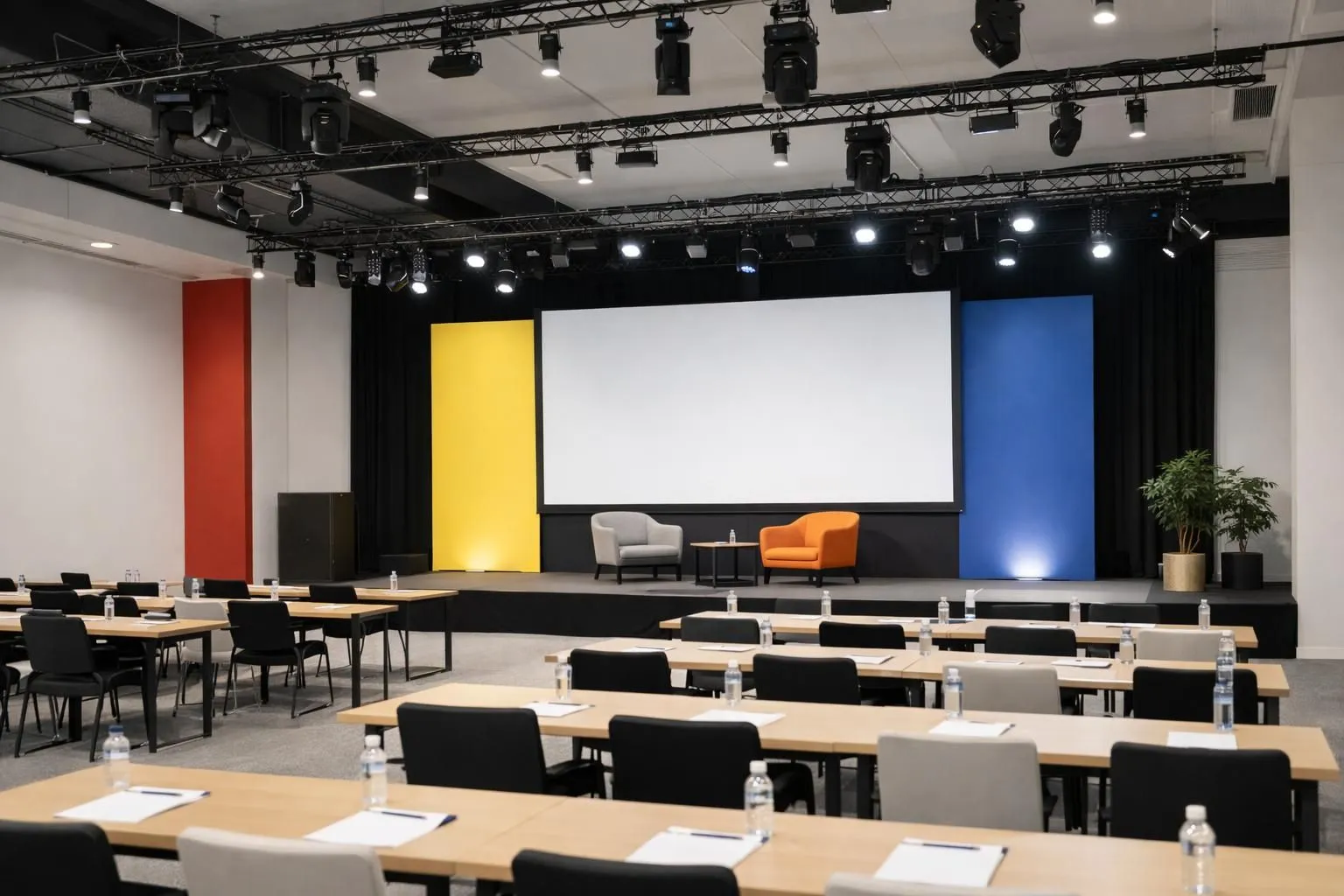 Modern corporate event venue in Switzerland with professional lighting setup, arranged conference tables, presentation screen, and elegant staging ready for business gathering, photographed from angle showing complete room setup without any text or signage visible