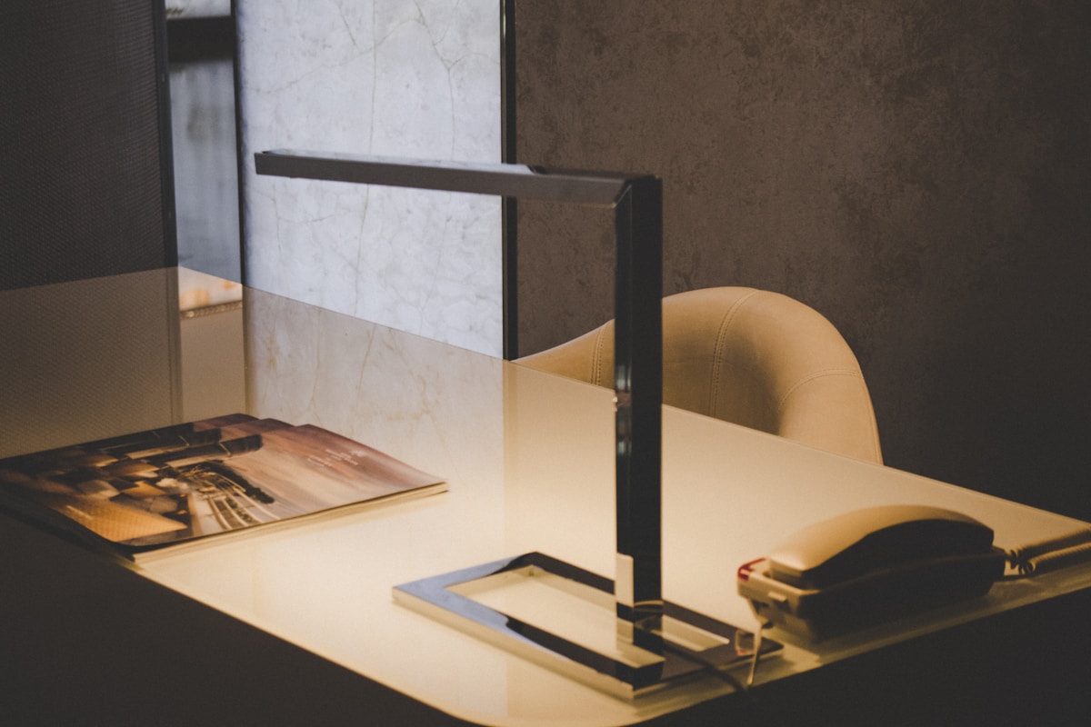 Bureau de travail avec lampe, livres et cadres.