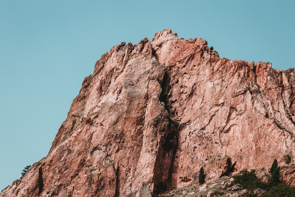 Falaise rocheuse rouge sous un ciel bleu turquoise.