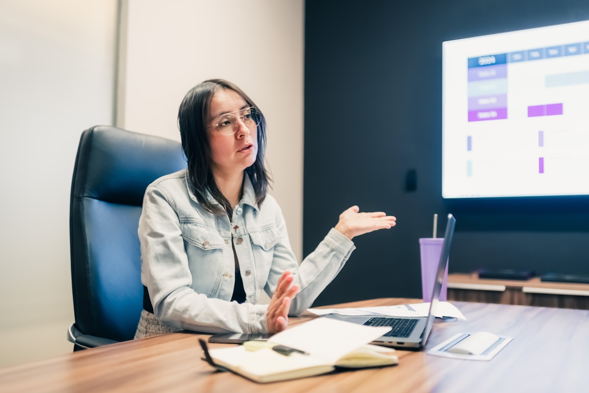 Femme assise à un bureau, travaillant sur un ordinateur portable.