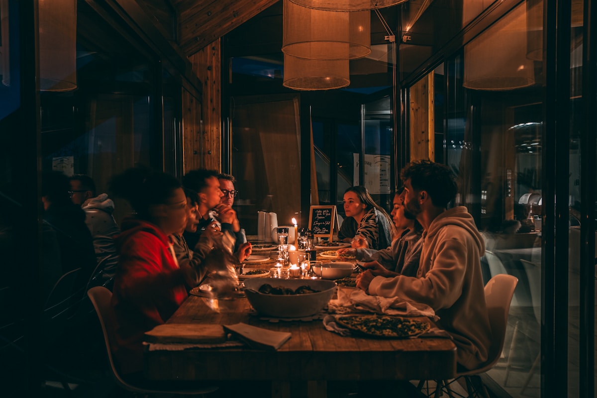 Groupe d'amis dînant dans un restaurant chaleureux et convivial.
