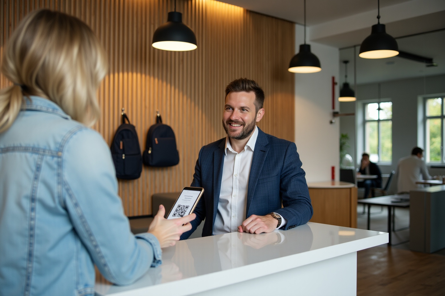 Homme d'affaires souriant accueillant une cliente dans un bureau moderne.