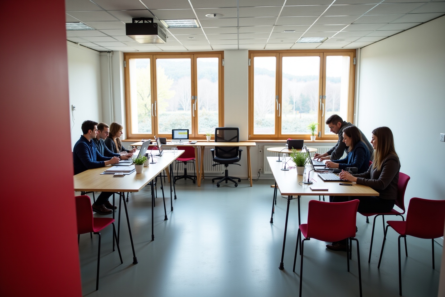 Salle de réunion moderne avec ordinateurs portables et employés travaillant.