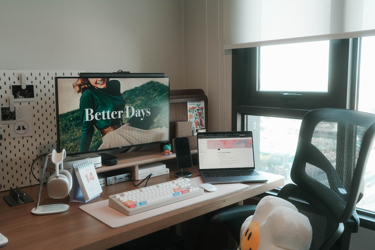 Bureau de travail avec ordinateur portable, accessoires et affiche "Better Days".