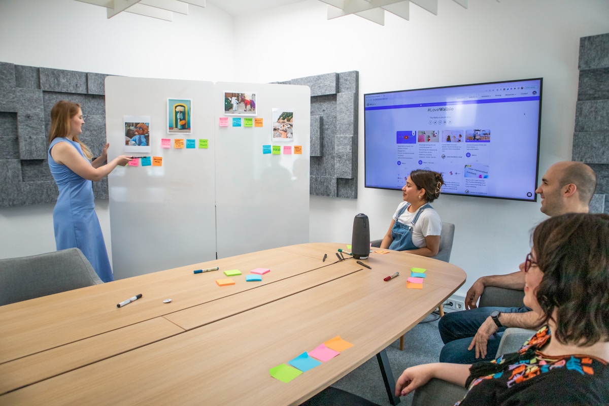 Salle de réunion moderne avec tableau blanc, écran et équipe de travail.