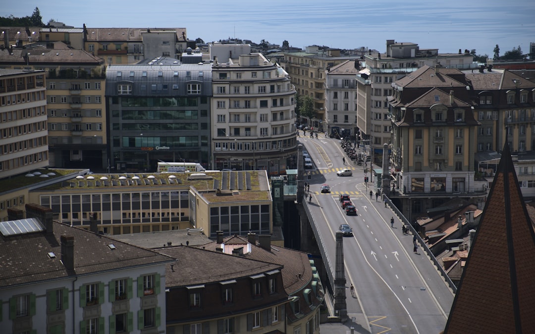 Vue de jour d'une rue animée de Lausanne avec voitures et bâtiments, un cadre propice au coworking pour indépendants.