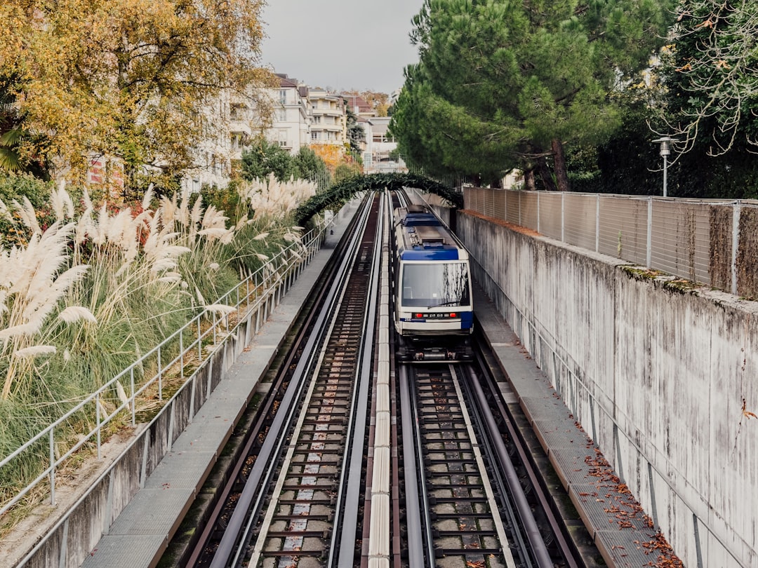 coworking à proximité transport public lausanne - A train travels on tracks through a city.