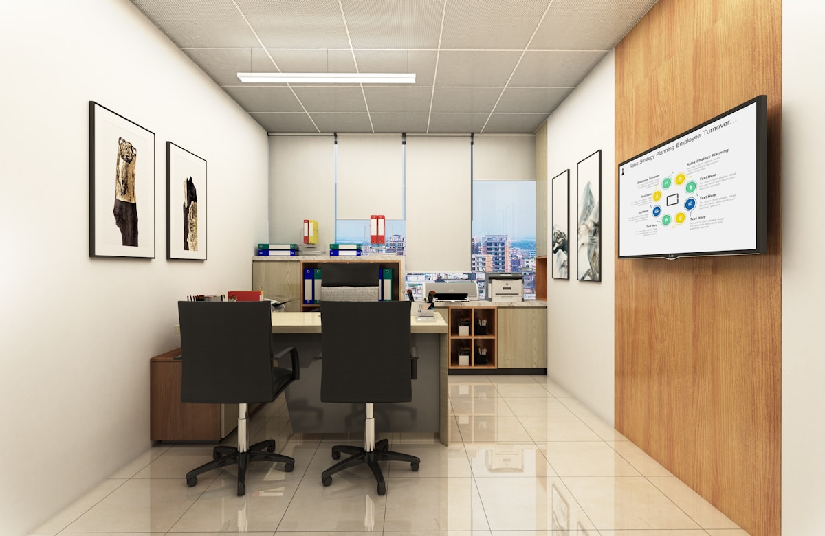 Un bureau moderne avec des bureaux, des chaises et un écran de présentation.
