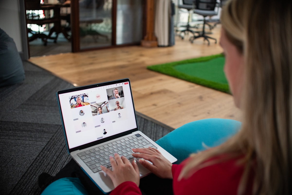 Personne utilisant un ordinateur portable pour une réunion virtuelle dans un bureau.