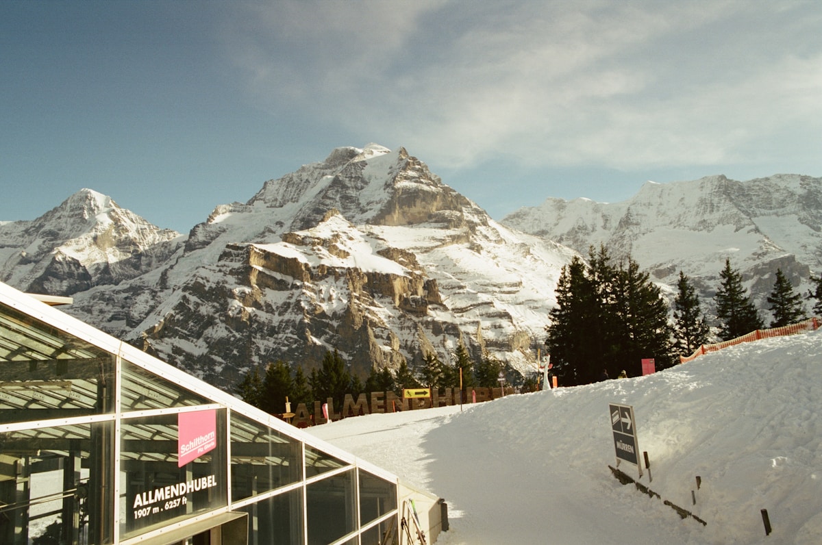 Paysage montagneux enneigé avec bâtiment et panneaux.