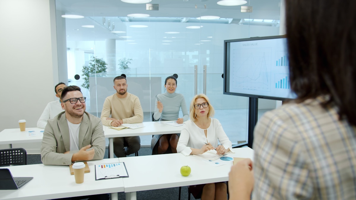 Réunion d'équipe dans un bureau moderne avec écran de présentation.