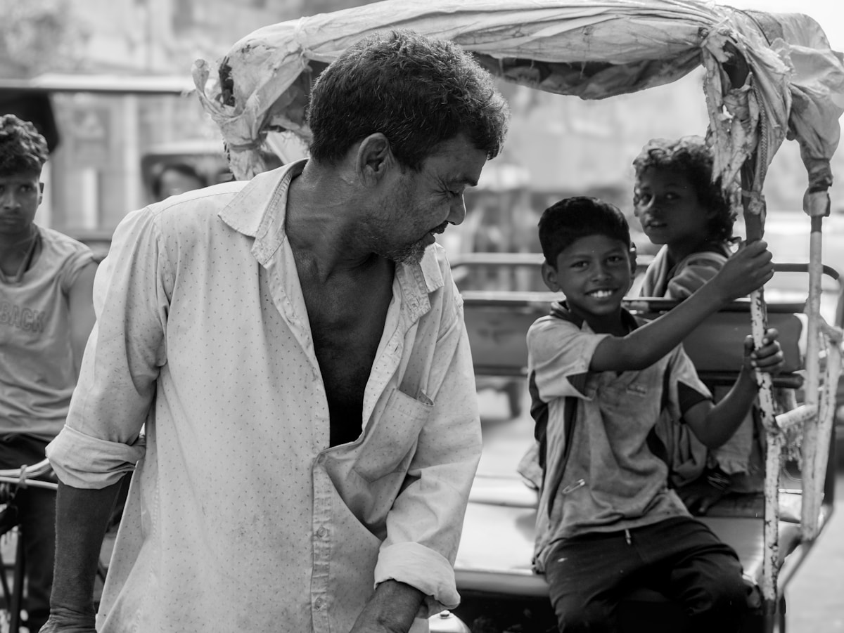 Un homme avec des enfants dans un pousse-pousse.