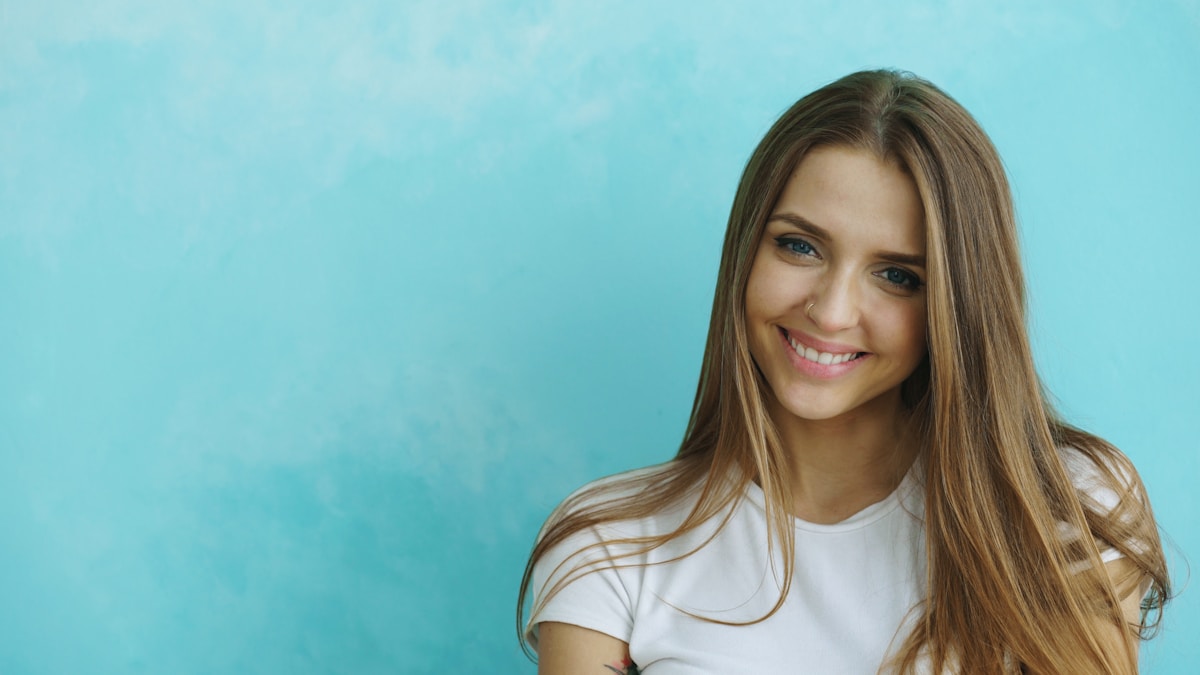 Une jeune femme souriante aux longs cheveux bruns.