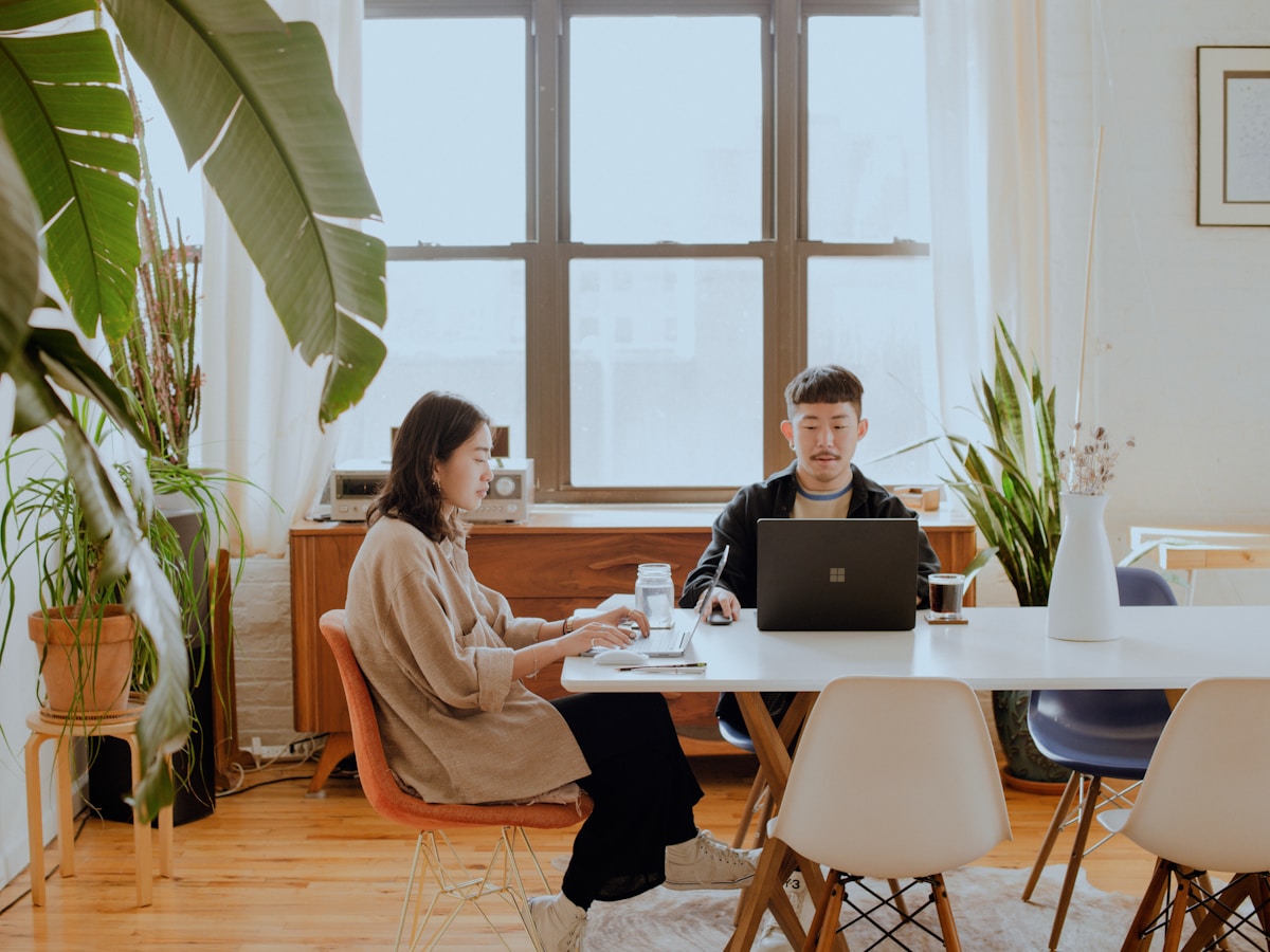 Deux personnes travaillant ensemble dans un espace de travail lumineux et moderne.